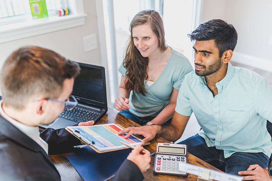 Couple face à un professionnel de crédit qui propose une offre