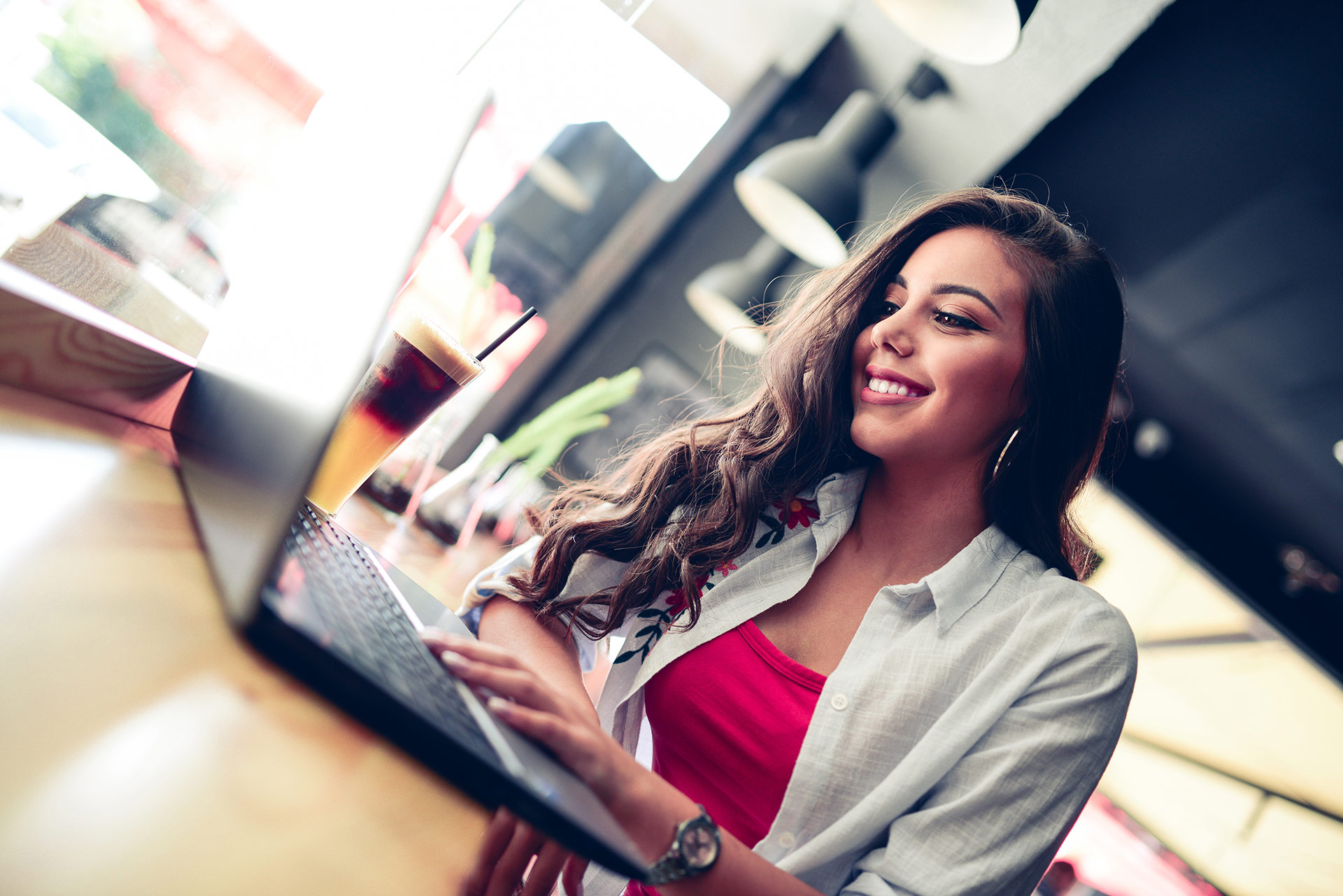 Femme qui sourit devant son laptop